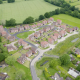 Drone camera shot of housing estate with greenery surrounding area